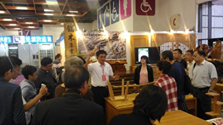 李界煌(中)在展位上开讲“古代建筑是现代经济困顿的解药”,吸引许多民众倾听。(廖素贞/大纪元)