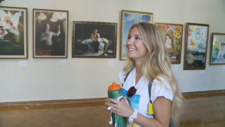 UCLA法轮大法社团的成员Joyce Kuo向Bianca Marcello解释画展背景。(杨阳/大纪元)