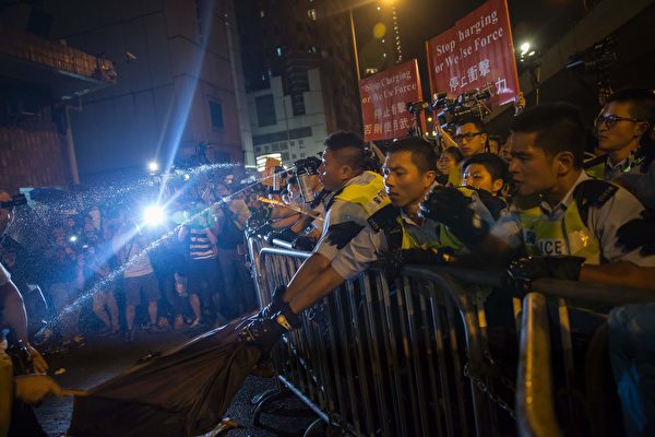 Police use pepper spray to stop protesters charging outside the Chinese Liason Office in Hong Kong on November 6, 2016, during a protest against an expected interpretation of the city's constitution -- the Basic Law -- by China's National People's Congress Standing Committee (NPCSC) over the invalid oath-taking attempts by newly elected lawmakers Baggio Leung and Yau Wai-ching at the Legislative Council last month. Thousands took to Hong Kong's streets on November 6 after Beijing said it would step into an escalating row over whether two city lawmakers who advocate a split from China should be banned from taking up their seats. / AFP / ISAAC LAWRENCE (Photo credit should read ISAAC LAWRENCE/AFP/Getty Images)
