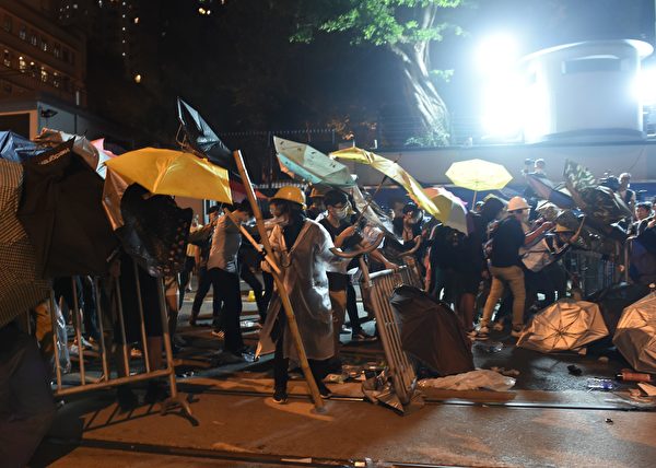 Demonstrators protect themselves with umbrellas during a stand-off with police during ongoing protests in Hong Kong on November 6, 2016. Hong Kong police used pepper spray November 6 to drive back hundreds of protesters angry at China's decision to intervene in a row over whether two pro-independence lawmakers should be barred from the city's legislature. In chaotic scenes reminiscent of mass pro-democracy protests in 2014, demonstrators charged metal fences set up by police outside China's liaison office in the semi-autonomous city. / AFP / Anthony WALLACE (Photo credit should read ANTHONY WALLACE/AFP/Getty Images)