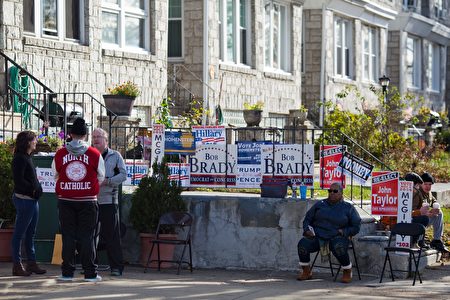 Volunteers wait for voters outside a polling station in Philadelphia, Pennsylvania, on election day November 8, 2016. America's future hung in the balance Tuesday as millions of eager voters cast ballots to elect Democrat Hillary Clinton as their first woman president, or hand power to the billionaire populist Donald Trump. As the world held its collective breath, Americans were called to make a historic choice between two radically different visions for the most powerful nation on Earth. / AFP / DOMINICK REUTER (Photo credit should read DOMINICK REUTER/AFP/Getty Images)