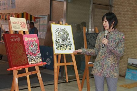 梁曉勤版畫家講述畫中公雞的蹄鳴帶來富裕及希望。(郭千華/大紀元)