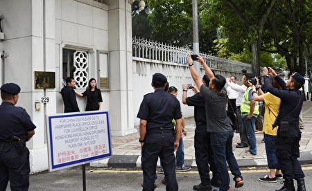 法輪功學員代表到中共駐馬大使館遞交抗議信,引起多位警官的關注。 (吳俐穎/大紀元)