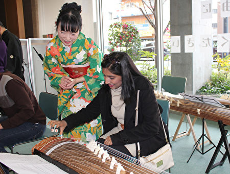 日本廣島市留學生會館於12月17日為留學生主辦「日本文化博覽會」。圖為留學生體驗古箏。(曉玥/大紀元)