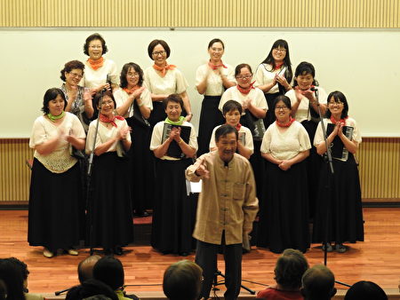 旅奥音乐家谢英杰老师(前立者),在“平安喜乐合唱音乐会”中,宣布将指挥棒传承给团长萧丽华。(蔡上海/大纪元)