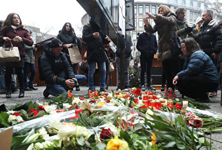 在遭受卡车恐袭的柏林圣诞市场的入口处，柏林市民在次日点燃蜡烛，献上鲜花，以表悼念。（Sean Gallup／Getty Images）