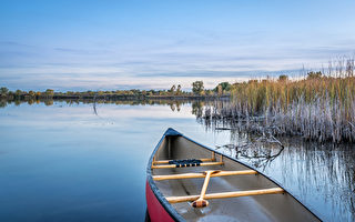 dusk over calm lake with a canoe