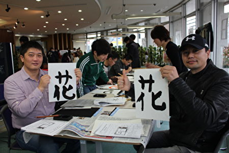 日本廣島市留學生會館於12月17日為留學生主辦「日本文化博覽會」。圖為來自蒙古國的步瑪(左)和朋友體驗書法 。(曉玥/大紀元)