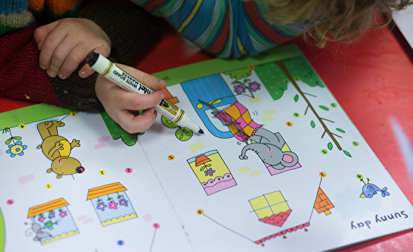 RADSTOCK, UNITED KINGDOM - JANUARY 06: A young girl draws at a playgroup for pre-school aged children in Chilcompton near Radstock on January 6, 2015 in Somerset, England. Along with the health and the economy, education and childcare are to be key issues in the forthcoming election. (Photo by Matt Cardy/Getty Images)