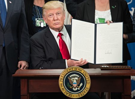 TOPSHOT - US President Donald Trump signs an executive order to start the Mexico border wall project at the Department of Homeland Security facility in Washington, DC, on January 25, 2017. / AFP / NICHOLAS KAMM (Photo credit should read NICHOLAS KAMM/AFP/Getty Images)