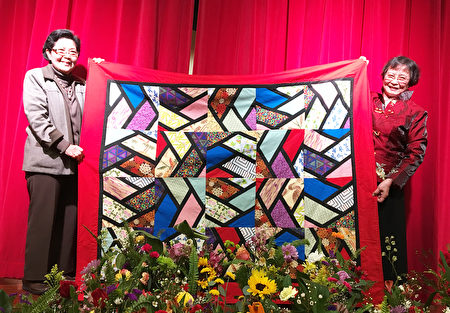 聖地亞哥臺灣中心和臺美基金會近日舉行20週年慶募款餐會。圖為年過八旬的黃玉貞（右）縫製的彩布拼毯拍賣。左為得標者之一。（楊婕／大紀元）