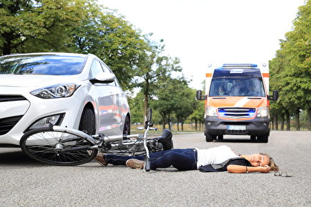 Frau liegt nach Fahrradunfall auf Strae mit Krankenwagen Frau liegt nach Fahrradunfall auf Strae mit Krankenwagen