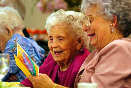 LOS ANGELES, CA - AUGUST 16: Mamie Underhill (L), 104, and her daughter Leita Chapman laugh while reading a birthday card for Mamie during a birthday celebration for five women residents at the Solheim Lutheran Home who are 100-years-old or more August 16, 2002 in Los Angeles, California. Mamie turns 105 on September 19. (Photo by David McNew/Getty Images)