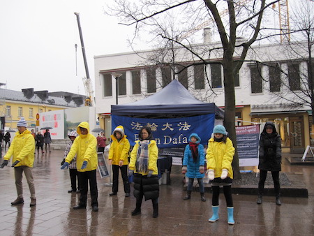 芬兰法轮功学员在首都市中心征签现场集体炼功。（李乐/大纪元）