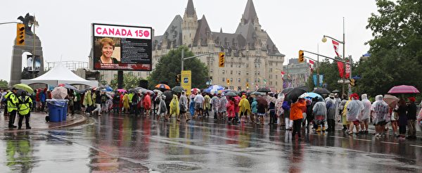 lineInRain.jpg：国会山前，人们在雨中排队等待安检。（梁耀/大纪元）