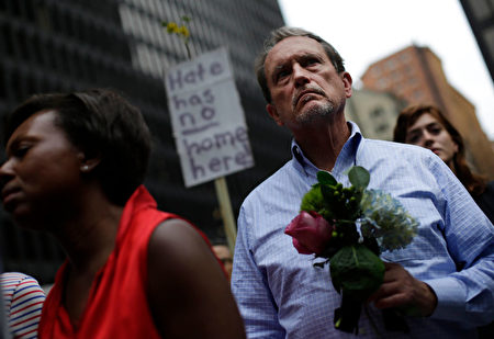 A man holds flowers at a vigil August 13, 2017 in Chicago, Illinois for the victims in the previous day's violent clashes in Charlottesville, Virginia. Heather Heyer was killed and 19 people were injured in the city of Charlottesville when a car plowed into a crowd of people after a rally by Ku Klux Klan members and other white nationalists turned violent. Two state police officers died in a helicopter crash near the area. / AFP PHOTO / Joshua Lott (Photo credit should read JOSHUA LOTT/AFP/Getty Images)