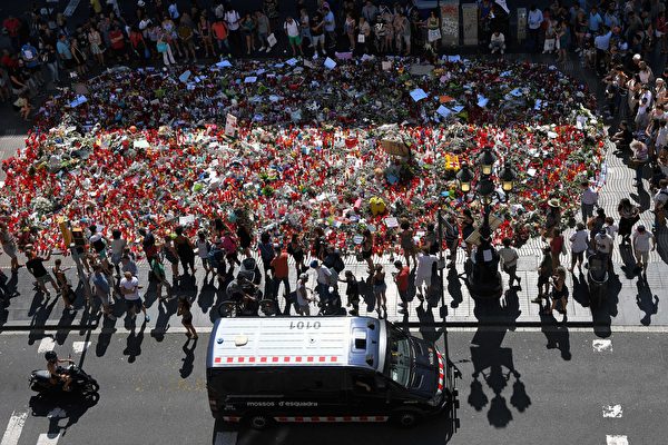 8月22日，西班牙巴塞罗那市民众在街头献上花束、点燃蜡烛，为上周恐袭中的15名遇难者致哀。(LLUIS GENE/AFP/Getty Images)