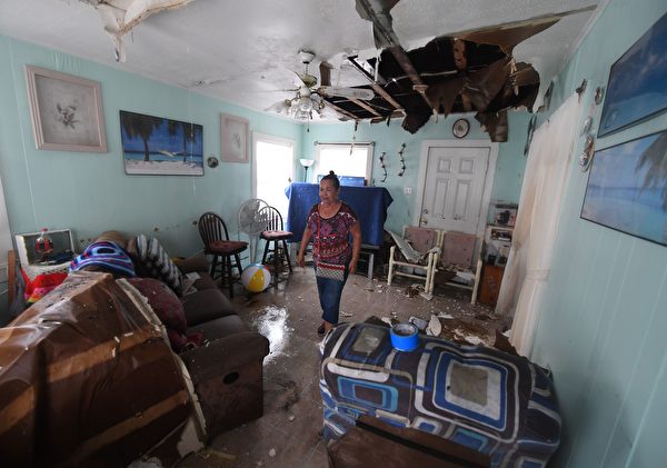 TOPSHOT - Celina Martinez returns to find her family home badly damaged after Hurricane Harvey hit Rockport, Texas on August 26, 2017. / AFP PHOTO / MARK RALSTON (Photo credit should read MARK RALSTON/AFP/Getty Images)