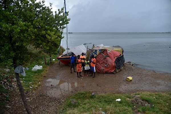 图为海地一个家庭前往庇护所。预计艾玛飓风9月7日将在多米尼加共和国和海地的北部边缘擦过，并继续往古巴东部。（AFP PHOTO / HECTOR RETAMAL）
