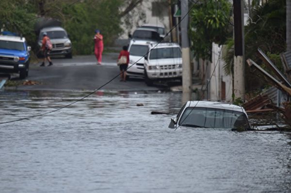 9月21日，一輛汽車被困在波多黎各聖胡安的淹水街道。（ AFP PHOTO / HECTOR RETAMAL）