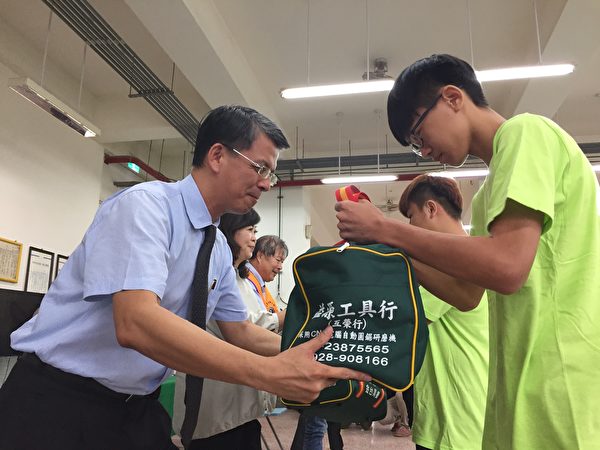 台湾行动菩萨助学协会理事长陈志声赠送木工袋，希望孩子早日出师。（谢平平／大纪元）