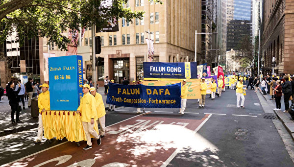 9月8日，澳洲法轮功学员的游行队伍穿过悉尼市商务中心，附近上班族驻足观看。（安平雅／大纪元）