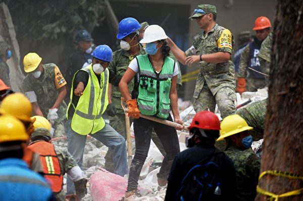 救灾现场，每个人都在贡献自己的一份力量。( LUIS MANUEL PEREZ/AFP/Getty Images)
