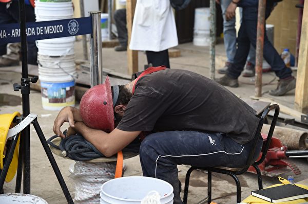 9月21日，一名参与营救的男子疲惫不堪，在救援现场睡着了。(ALFREDO ESTRELLA/AFP/Getty Images)