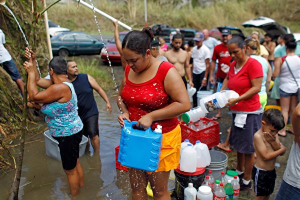 波多黎各居民排隊接山泉水。(RICARDO ARDUENGO/AFP/Getty Images)