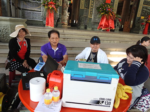 台湾卧龙爱心会在卧龙港代天府庙前广场举办爱心慈善活动，由东石乡卫生所主任罗清福（左2）所带领的医疗团队，也到场为老人家做流感疫苗注射服务。（蔡上海／大纪元）