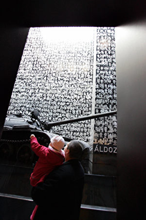 在“恐怖屋”博物馆的一楼，陈列着一辆前苏联的坦克，后面墙上贴着3200名在此地遇害的受难者的相片。（ATTILA KISBENEDEK/AFP/Getty Images)