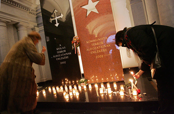 图为2007年2月25日，在纪念共产主义受难者当天，民众在博物馆的纪念碑前点亮蜡烛。(ATTILA KISBENEDEK/AFP/Getty Images)