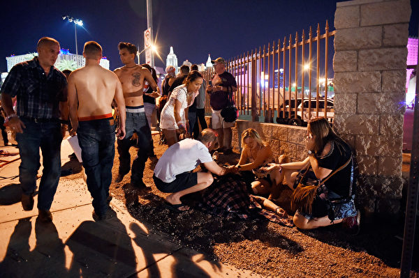 LAS VEGAS, NV - OCTOBER 01: People tend to the wounded outside the Route 91 Harvest Country music festival grounds after an apparent shooting on October 1, 2017 in Las Vegas, Nevada. There are reports of an active shooter around the Mandalay Bay Resort and Casino. (Photo by David Becker/Getty Images)