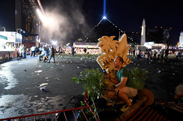 LAS VEGAS, NV - OCTOBER 01: A person takes cover at the Route 91 Harvest country music festival after apparent gun fire was heard on October 1, 2017 in Las Vegas, Nevada. There are reports of an active shooter around the Mandalay Bay Resort and Casino. (Photo by David Becker/Getty Images)