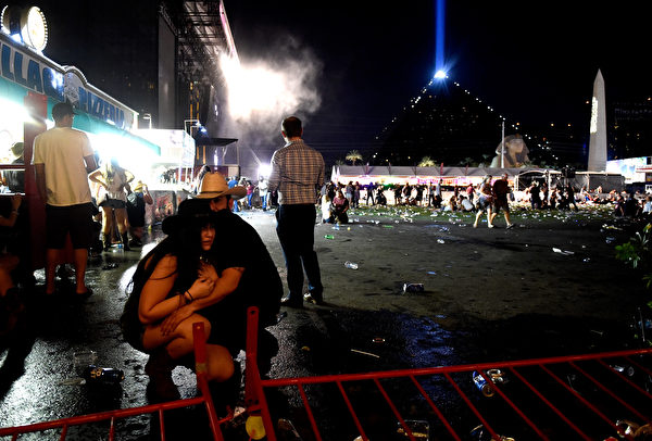 LAS VEGAS, NV - OCTOBER 01: People take cover at the Route 91 Harvest country music festival after apparent gun fire was heard on October 1, 2017 in Las Vegas, Nevada. There are reports of an active shooter around the Mandalay Bay Resort and Casino. (Photo by David Becker/Getty Images)