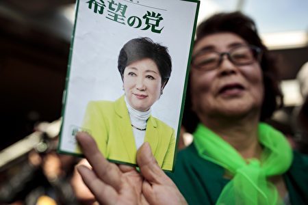 In this picture taken on October 18, 2017, a woman shows an electoral leaflet of Tokyo Governor and leader of the Party of Hope Yuriko Koike during an election campaign in Saitama. Tokyo governor Yuriko Koike is a media-savvy veteran who has charmed her way through Japan's male-dominated politics and transformed its sleepy political landscape with a wildcard new party that caught everyone off-guard. Koike stunned the establishment by unveiling her new conservative "Party of Hope", seeking to offer an alternative to Prime Minister Shinzo Abe's long-ruling Liberal Democratic Party. / AFP PHOTO / Behrouz MEHRI / TO GO WITH ELECTION PROFILE "JAPAN-VOTE-KOIKE" BY HIROSHI HIYAMA (Photo credit should read BEHROUZ MEHRI/AFP/Getty Images)