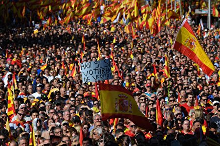 A protester holds a sign reading "Now yes, yes, we will vote for real" amid a wave of Spanish flags during a pro-unity demonstration in Barcelona on October 29, 2017. Pro-unity protesters were to gather in Catalonia's capital Barcelona, two days after lawmakers voted to split the wealthy region from Spain, plunging the country into an unprecedented political crisis. / AFP PHOTO / LLUIS GENE (Photo credit should read LLUIS GENE/AFP/Getty Images)