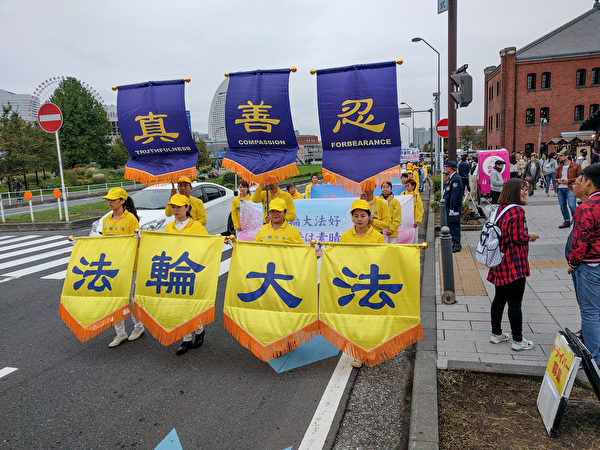 10月14日，日本法轮功学员在横滨举行了反迫害游行活动，真相条幅吸引了很多路人观看，中共活体摘取法轮功学员器官贩卖牟利的罪行受到当地民众的关注。（卢勇／大纪元）