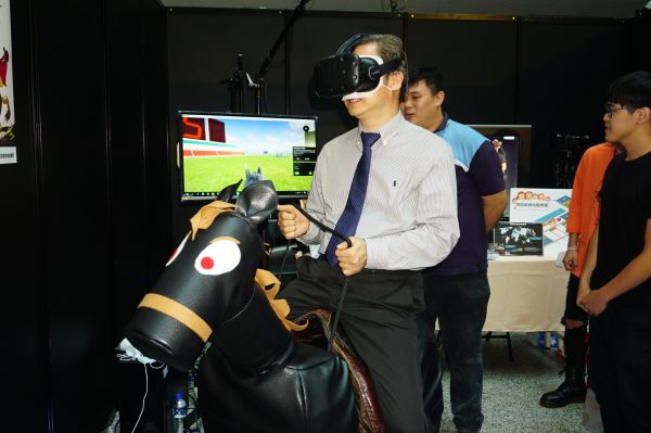 經濟部次長龔明鑫7日參加「台灣體感科技產業聯盟」在高雄成立大會，嘗試「馬術訓練體感座椅」。（李怡欣／大紀元）