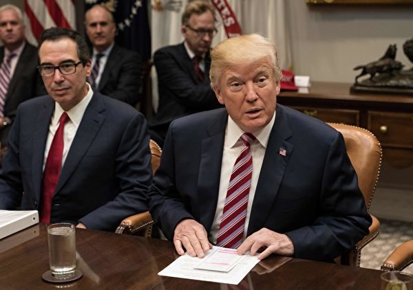 US President Donald Trump speaks at a meeting with business leaders on tax reform at the White House in Washington, DC, on October 31, 2017. On left, is Treasury Secretary Steve Mnuchin. / AFP PHOTO / NICHOLAS KAMM (Photo credit should read NICHOLAS KAMM/AFP/Getty Images)