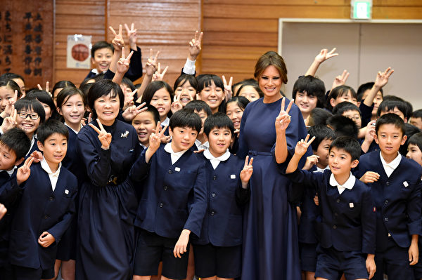 US First Lady Melania Trump poses with 4th graders at the Kyobashi Tsukiji elementary school in Tokyo on November 6, 2017. President Donald Trump lashed out at the US trade relationship with Japan, saying it was "not fair and open", as he prepared for formal talks with his Japanese counterpart. / AFP PHOTO / POOL / PING MA (Photo credit should read PING MA/AFP/Getty Images)