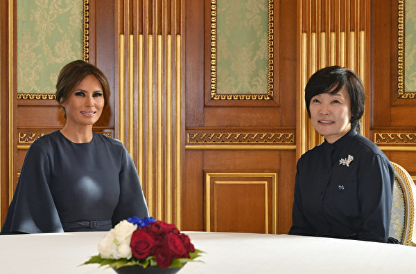 梅拉尼娅一袭Dior深蓝色阔袖中长裙，和日本第一夫人参观小学。(FRANCK ROBICHON/AFP/Getty Images)