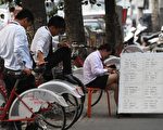 北京二手房市场持续低迷,近期现全面“砍价”行情。图为北京街头的地产经纪。(GREG BAKER/AFP/Getty Images)