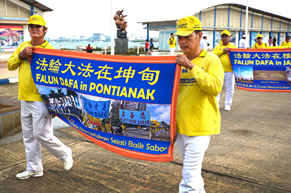 2018年印尼法轮功心得交流会前夕，法轮功学员在巴淡岛最大的游乐场Costarina游行。其次是横幅队伍。（Wayan Diantha 提供）