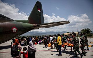 地震和海啸致240万人受灾 印尼合葬遇难者