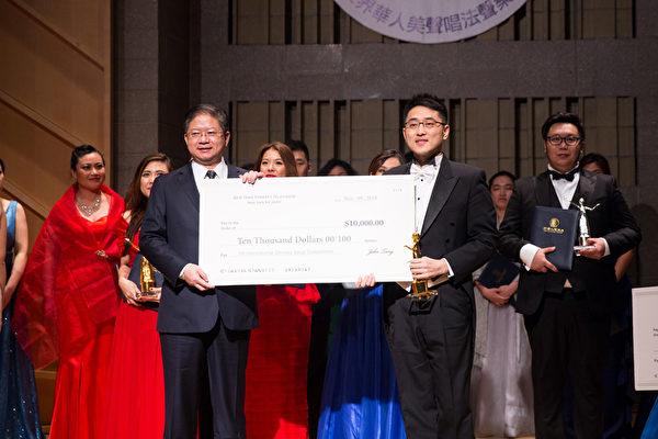 11月10日，新唐人电视台总裁唐忠（前排左一）向第七届“全世界华人美声唱法声乐大赛”比赛中获得金奖的男声组选手古韵（前排右一）颁奖。金奖奖金为1万美元。（戴兵／大纪元）