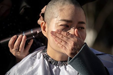12月17日，709家属王全璋妻子李文足哭泣着剃光自己的秀发，以此抗议天津二中院法官违法。(FRED DUFOUR/AFP/Getty Images)