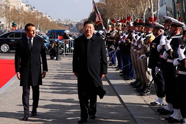 圖為3月25日檢閱儀仗隊時，法國總統馬克龍跟隨習近平慢慢前行。 (FRANCOIS MORI/AFP/Getty Images)