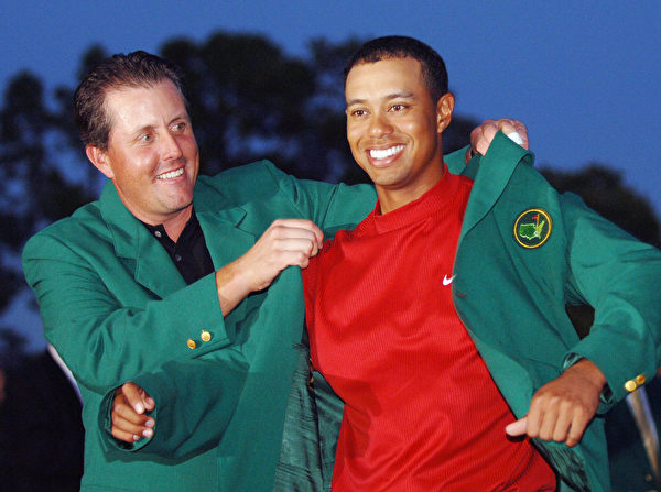 AUGUSTA, UNITED STATES: US golfer Tiger Woods (R) is awarded his green jacket by 2004 champion Phil Mickelson of the US at the 2005 Masters Golf Tournament Championship 10 April 2005 at the Augusta National Golf Club in Augusta, Ga. Woods claimed his 4th Masters title by defeating fellow American Chris DiMarco in a one-hole playoff. AFP PHOTO/Roberto SCHMIDT (Photo credit should read ROBERTO SCHMIDT/AFP/Getty Images)