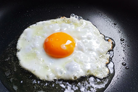 看到蛋白開始凝固時，可在雞蛋上灑2小勺熱水，馬上蓋上鍋蓋。(Shutterstock)